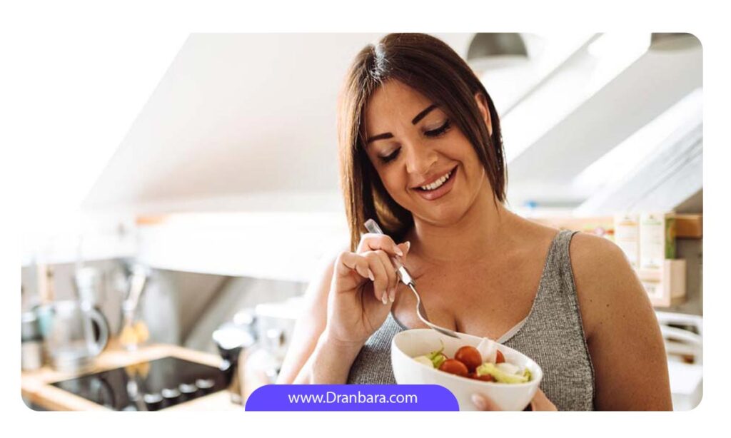 خانم بارداری که از کاسه حاوی سبزیجات سالم می خورد